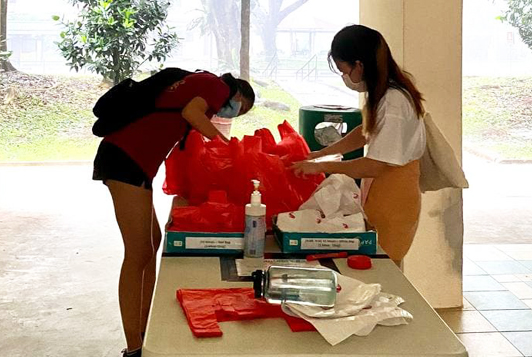 Jet Yee (Year 2, FoS) and Foo Yen Hui (Year 1, Biz) ensure that all meals remained dry before the scheduled delivery, 15 December 2020

