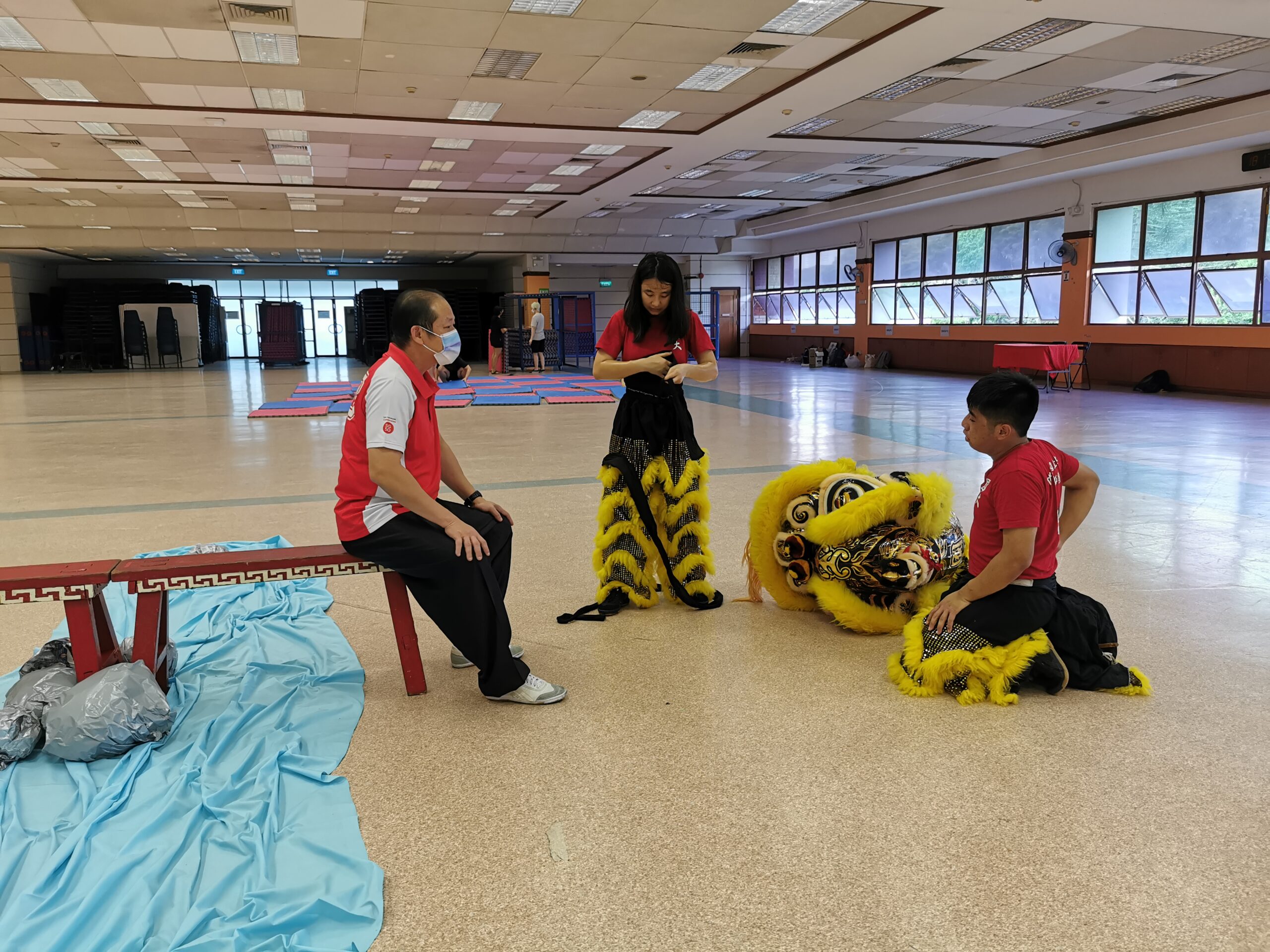 Nicole (standing in middle) and Jun Yu (on her right) kneeling on the floor as they gear up to display their prowess as the Lion’s body
