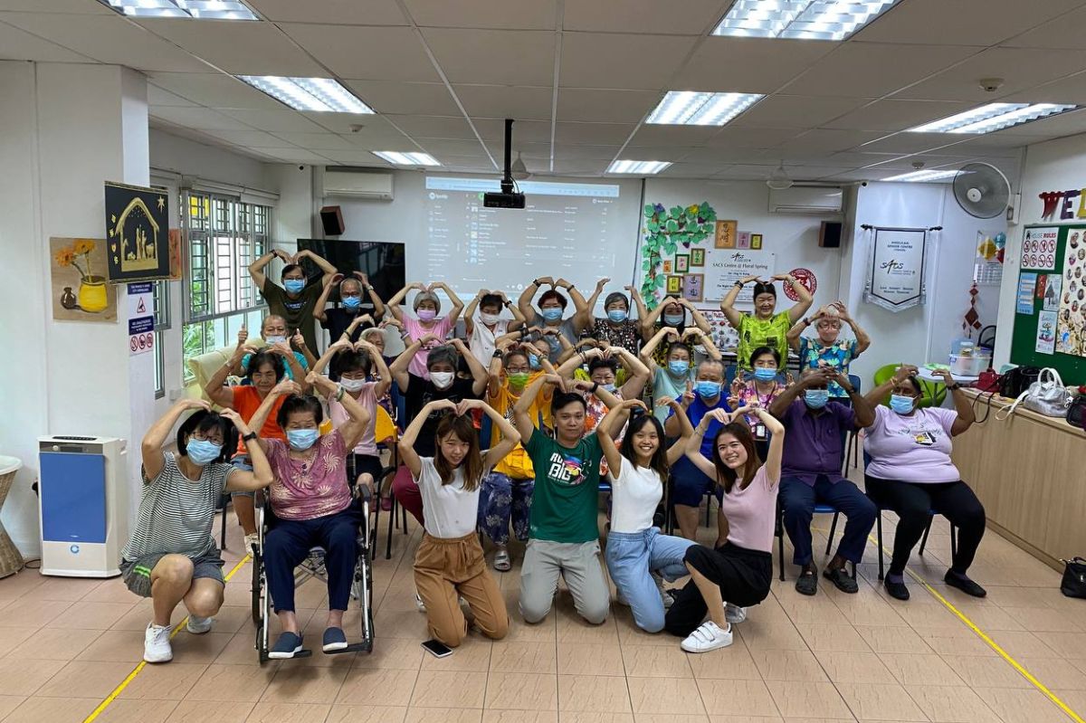 A group of student volunteers, Ang O Wen, Ng Shu En Lydia, Roanne Chew Wan Li and Celine Siah Wen Hui taking a picture with the seniors from Anglican Senior Centre (Yishun) after their interactive dance session.