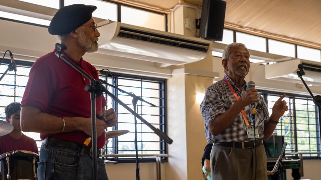 Dr Singh joins an alumnus in a rendition of a KE Hall song during the Medical Alumni Association’s centennial anniversary. 
