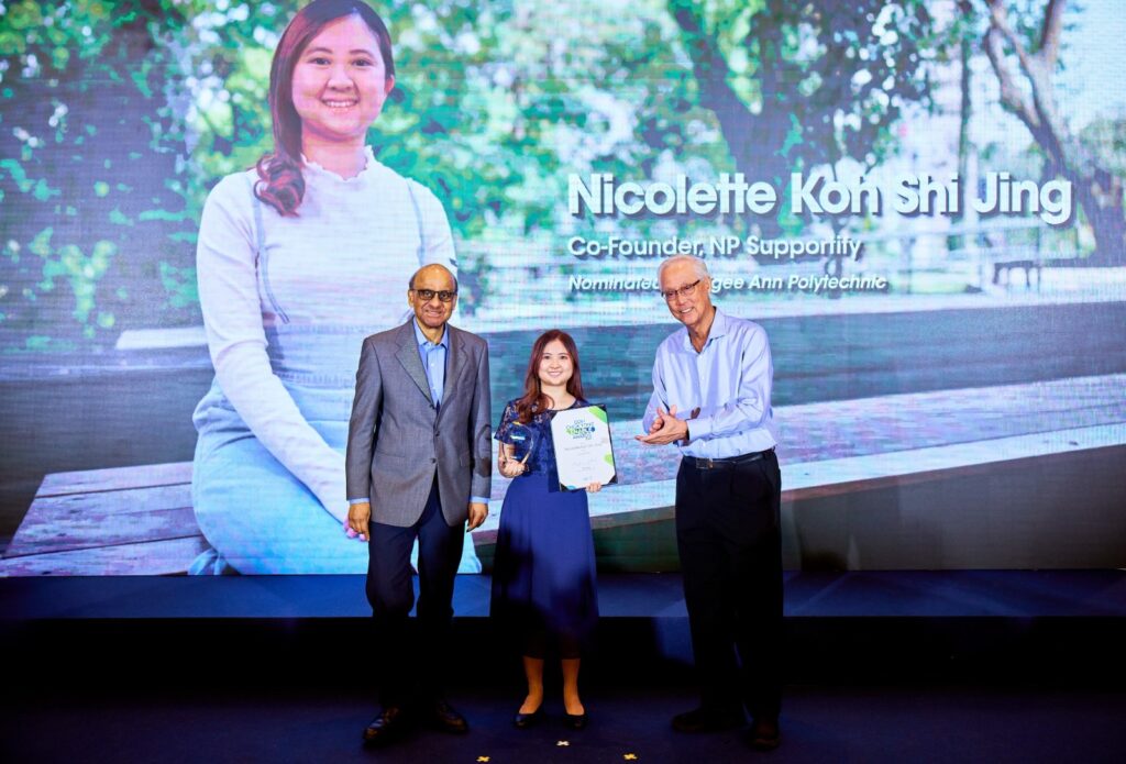 Nicolette Koh Shi Jing receiving her award from President Tharman and Emeritus Senior Minister Goh Chok Tong on stage. (Photo: Mediacorp)