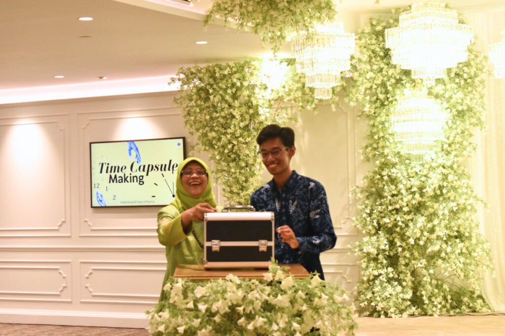Mdm Halimah and Sayyid Harith locking the time capsule, to be opened in 2064.