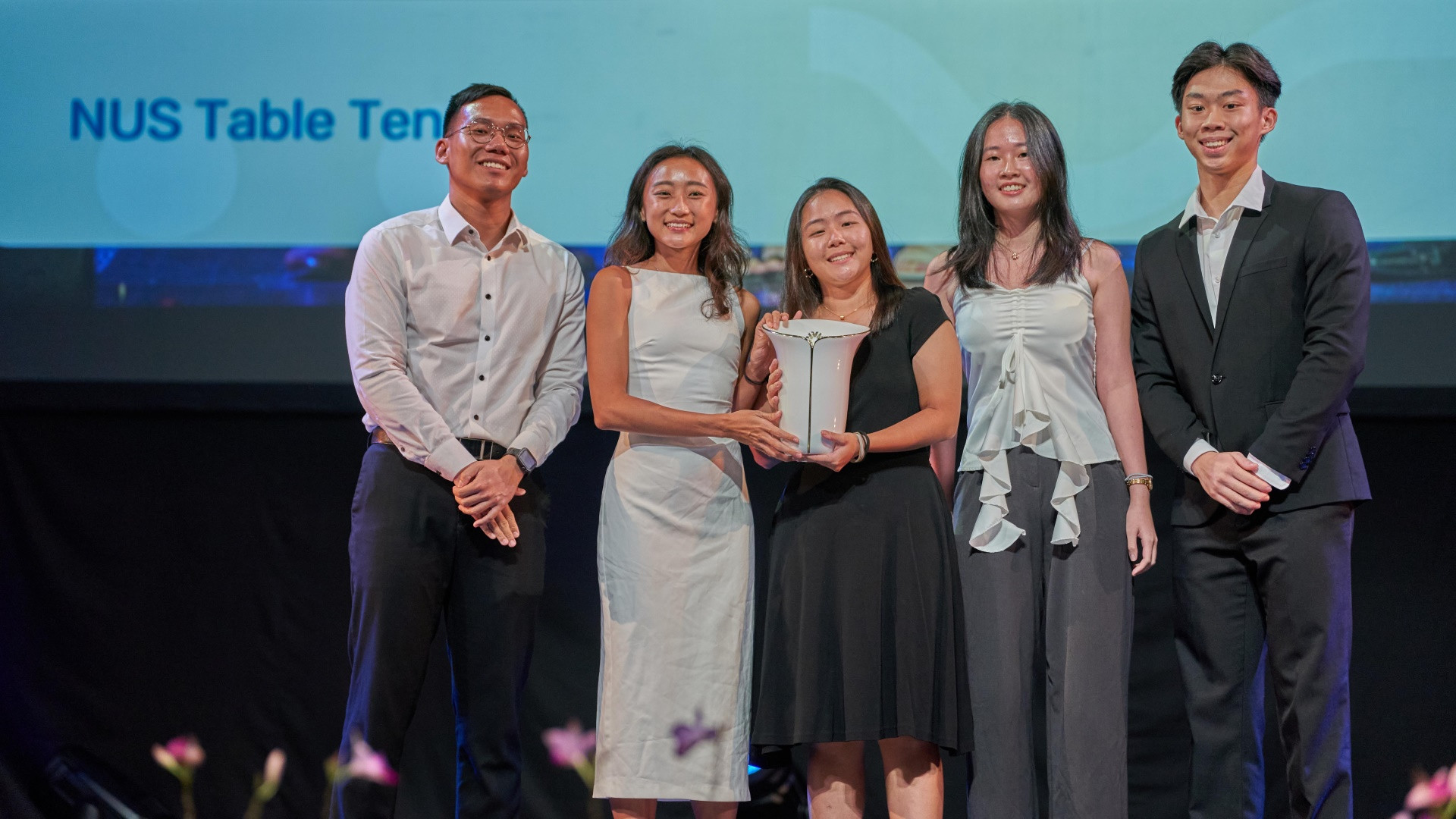 Janine (centre, in black) and her teammates from NUS Table Tennis receiving the Sports Team of the Year (Individual Sports) (Distinction) at the NUS Achievement Awards (NAA) 2024.