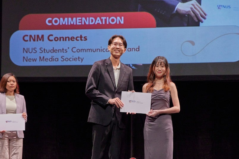 Lee Jia Xuan, Eilis (right), a third-year student at the Faculty of Arts and Social Sciences, accepted the award on behalf of CNM Connects from Bryan Sim En Jie, an NAA 2024 Community Impact Distinction recipient.