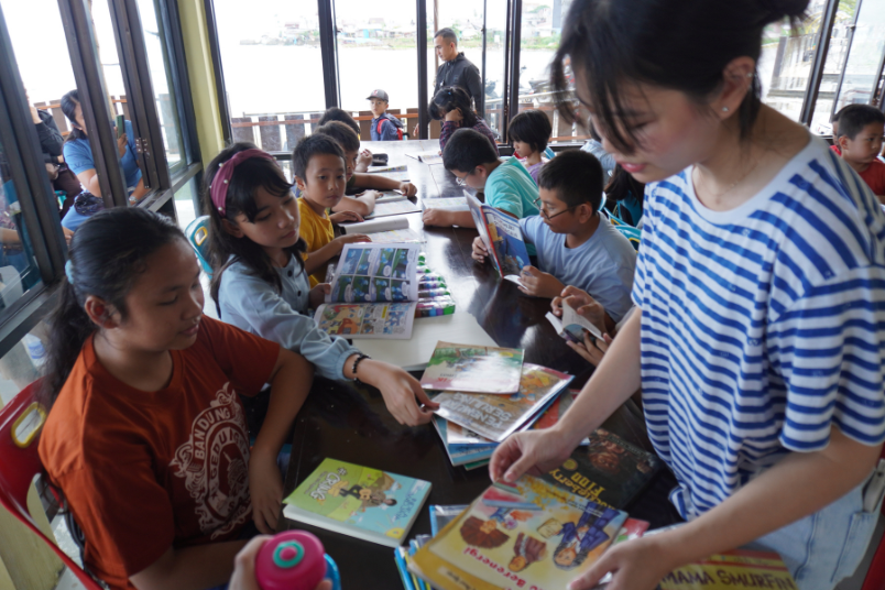 An Education Team member leading a literacy and reading session for the younger generation. 61 children from three schools were invited to the reading programme.