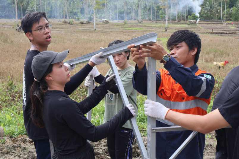 The Technology Team members constructing the solar panel with a local expert. 