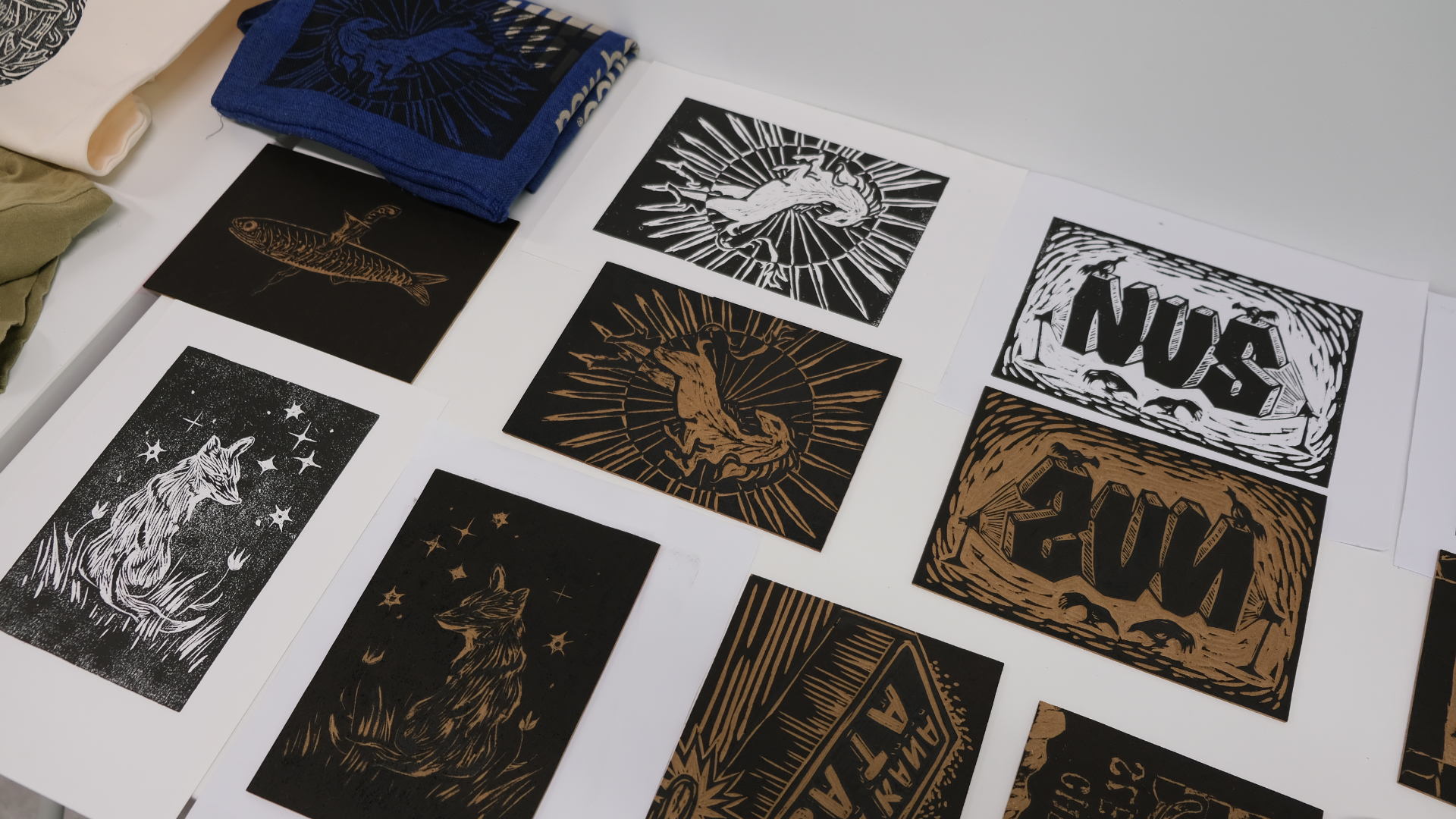 A vibrant array of creative practice designs and prints, displayed on tote bags, paper and T-shirts.