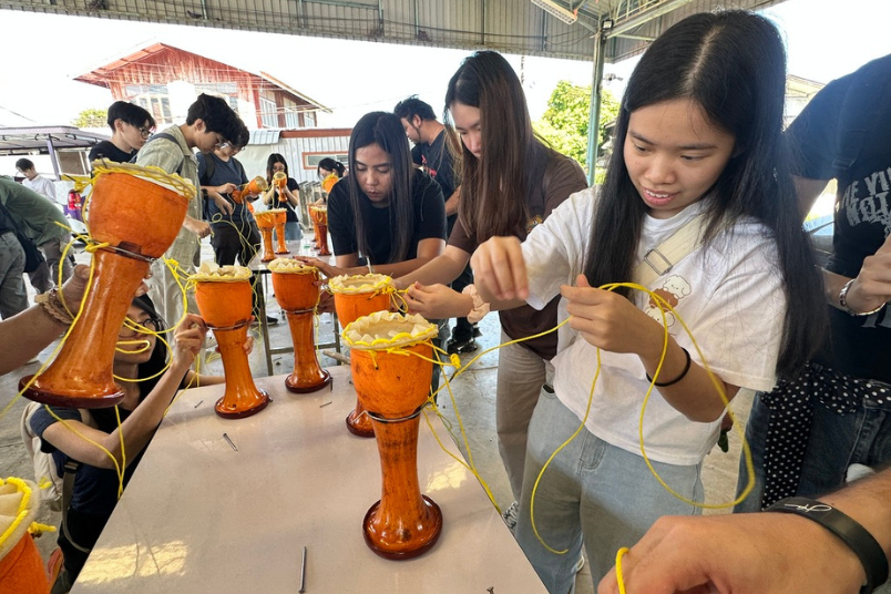 NUS students making and assembling their own drums at a workshop at the Ekkarat Drum Making Village in Thailand.