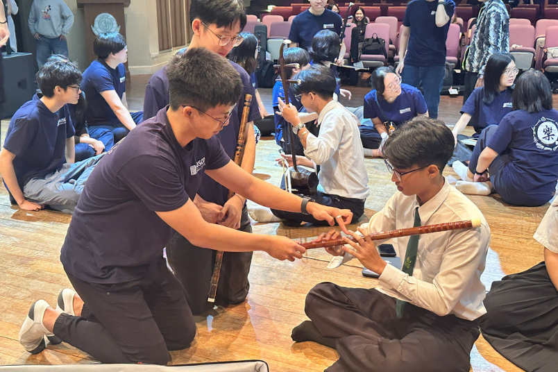 NUS Chinese Orchestra students introducing their music instruments to students from Kasetsart University.
