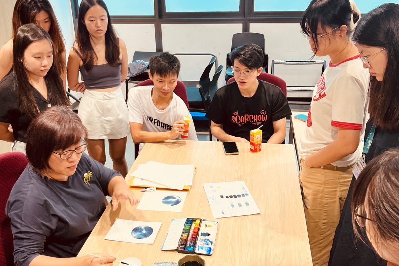 Invited artist and NUS Alumna Li Ching Heng guides students during the watercolour. 