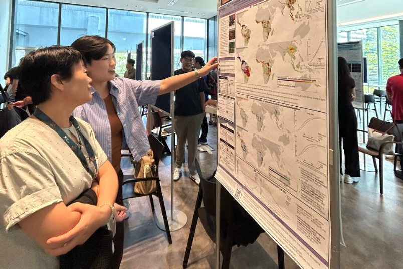 Xin Ee presenting her work in finding reforestation areas to reduce the risk of diseases spreading from wildlife at a poster exhibition.