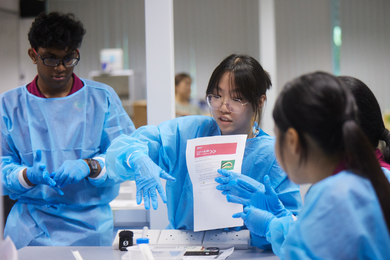 Amanda explaining a science concept to Unity Secondary School students.